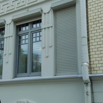 Здание - памятник архитектуры. Окна выполнены с сохранением первоначального вида. Ламинированы в серый цвет, наверху - декоративная раскладка. Рольставни также серого цвета с электроприводом.
